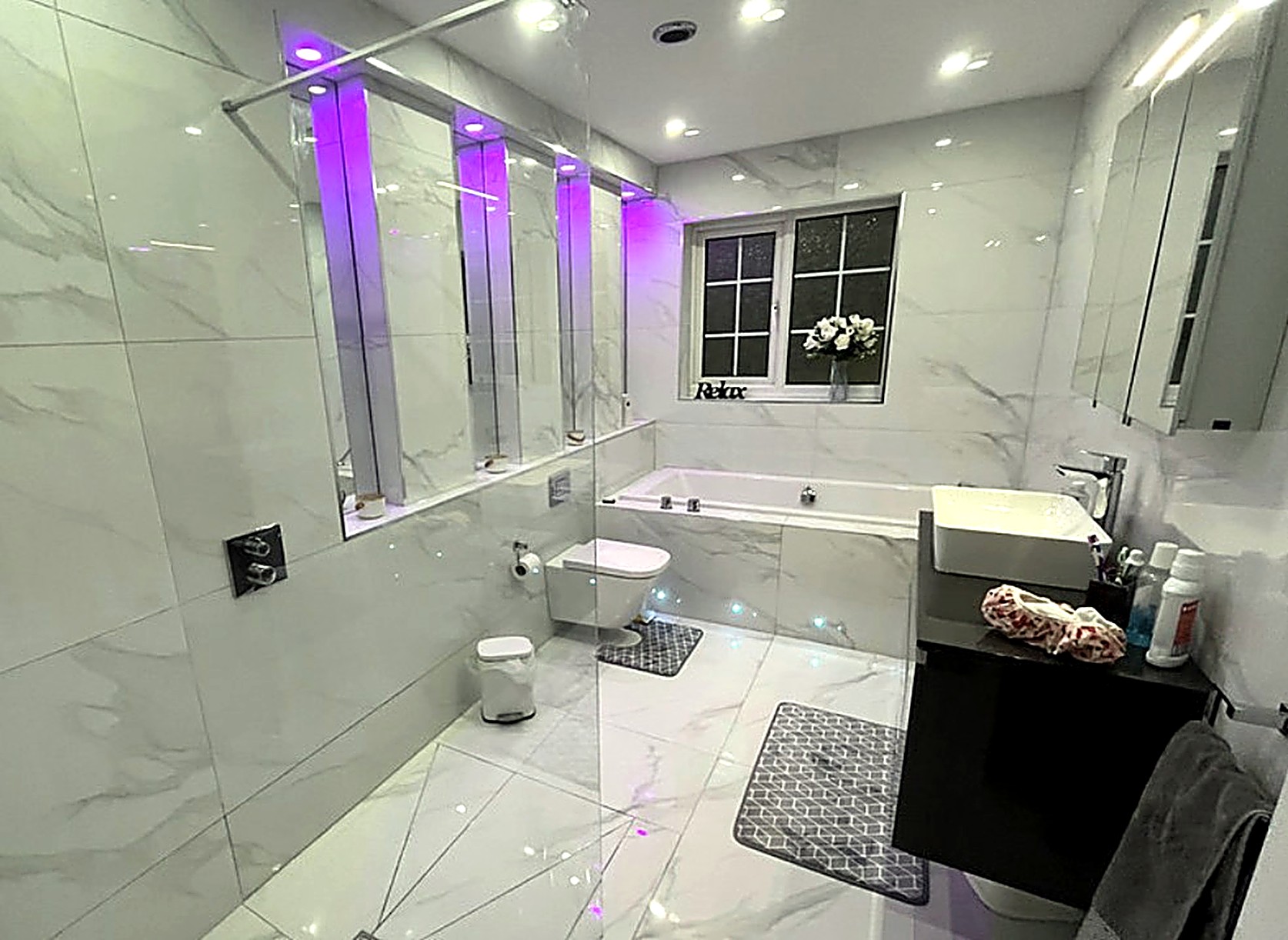 Marble-tiled family bathroom with mood lighting