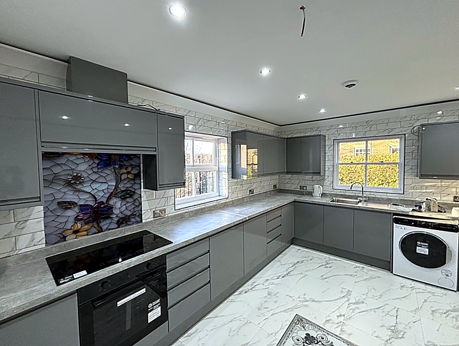 Gloss grey kitchen with mosaic splashback